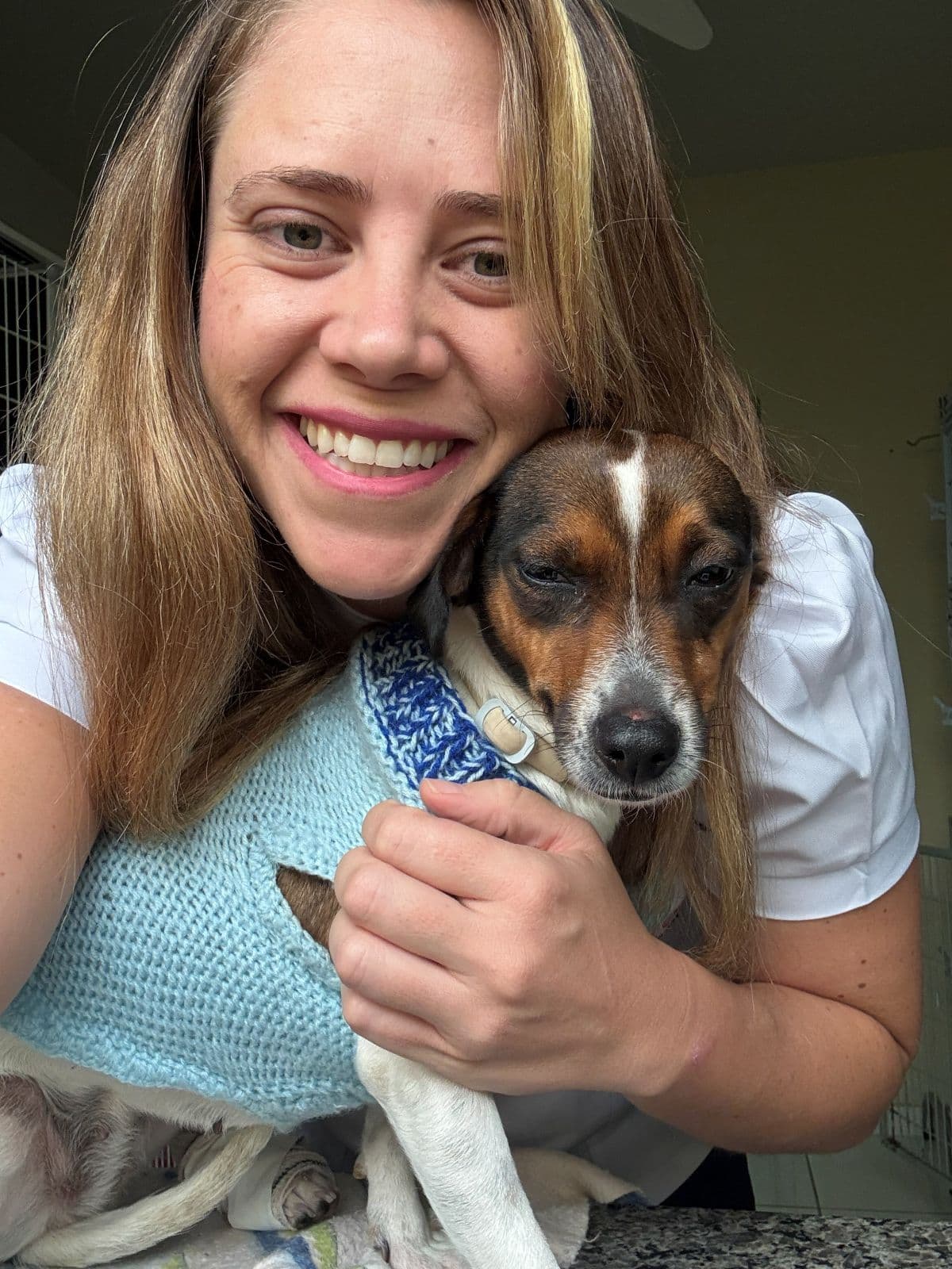 Profissional da Animal Care sorrindo ao lado de um cão